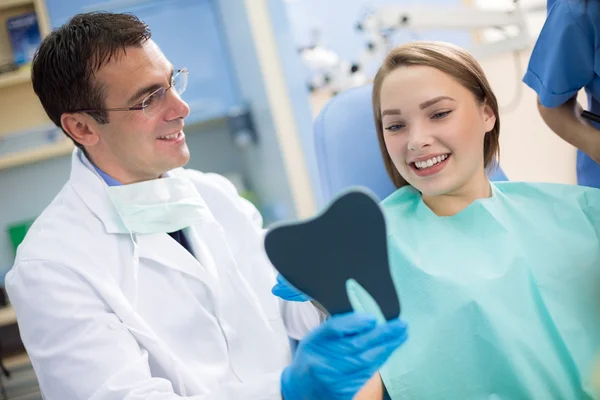 Dentiste montrer dents à fille avec miroir — Photo