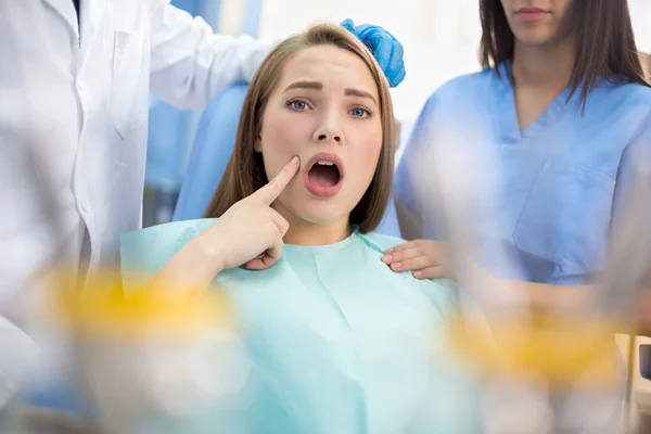 Dziewczyna w pogotowie stomatologiczne Pokaż ból miejscu — Zdjęcie stockowe