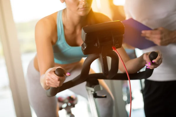 Femme en vélo d'appartement à la salle de gym — Photo