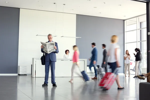 Бізнесмен читає газету під час очікування літака — стокове фото