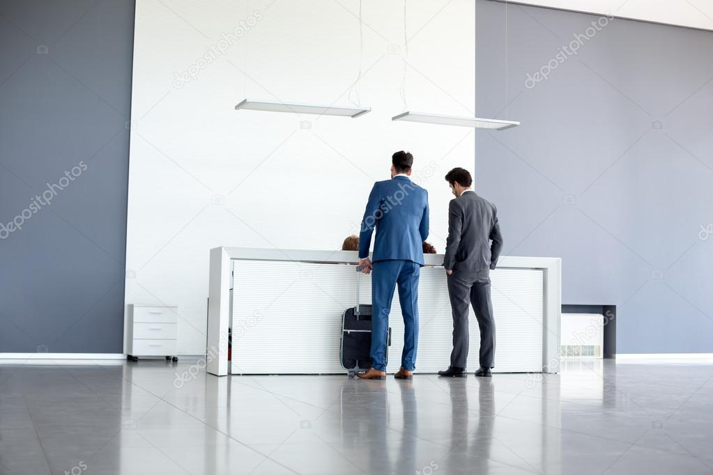 Businessmen check in at reception
