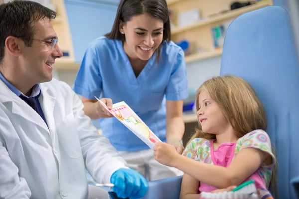 Fille chez le dentiste recevoir une carte de louange pour la bravoure — Photo