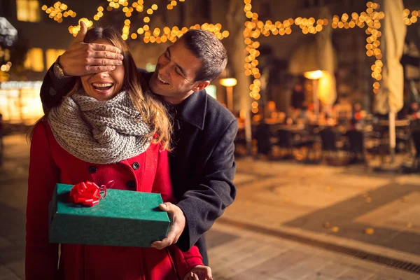 L'homme garde ses yeux de petite amie couverts tandis qu'elle donne un cadeau — Photo