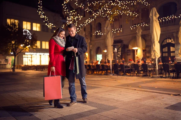 Trendpaar läuft mit Einkaufstasche durch die Innenstadt — Stockfoto