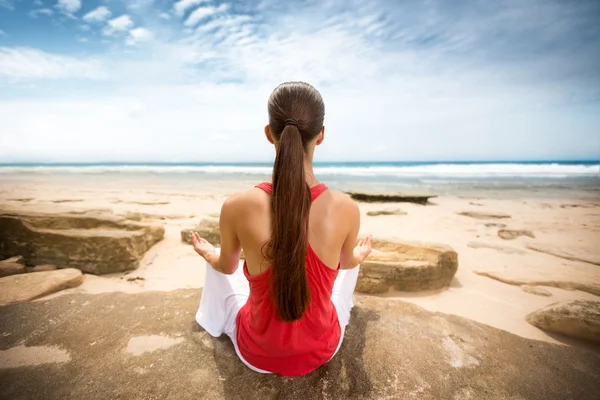 Мирная женщина медитирует у океана — стоковое фото