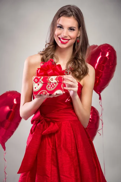 Красива усміхнена жінка з подарунком — стокове фото