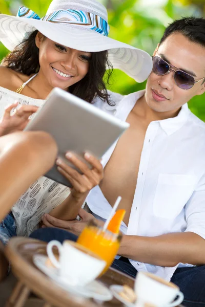 Jonge Aziatische paar met pc tablet op vakantie — Stockfoto