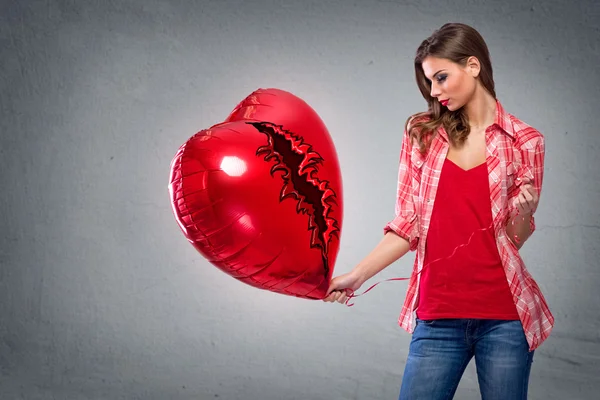 Woman holding a heart shaped balloon — Stock Photo, Image