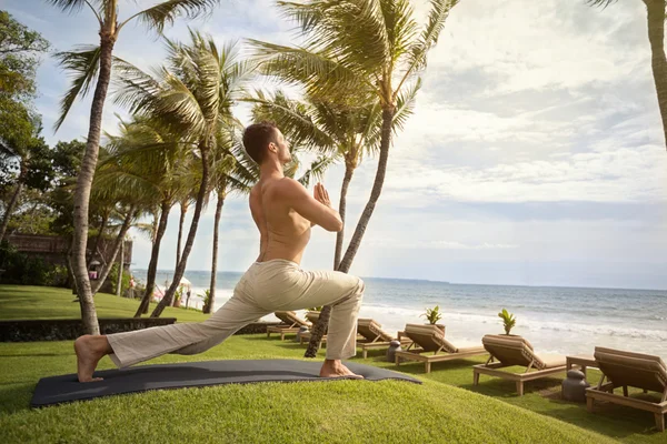 Йога-человек на тропическом пляже — стоковое фото