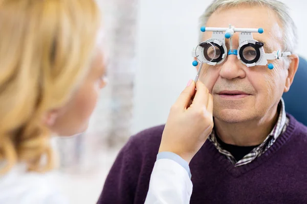 Optisk specialister just bestämmer dioptri till senior patie — Stockfoto