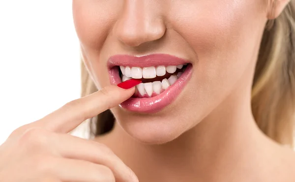 Sexy žena ústa s prstem mezi zuby — Stock fotografie