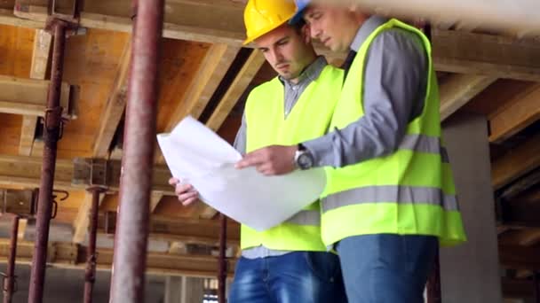 Ingeniero o arquitecto discutiendo temas de construcción con su colega — Vídeo de stock