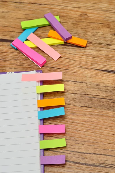 Notebook with bookmarks on wooden table — Stock Photo, Image