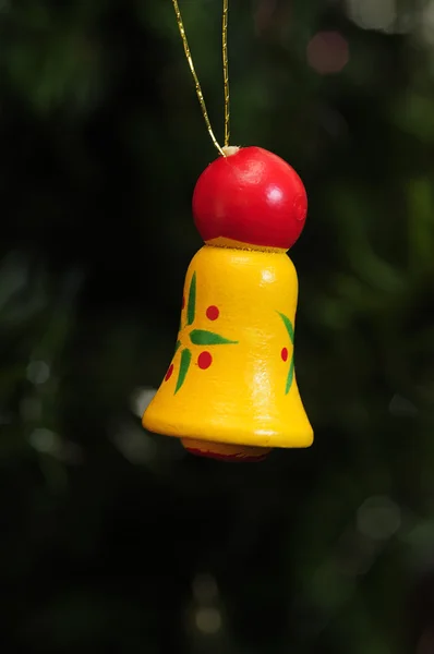 A yellow and red wooden bell to decorate a christmas tree — Stock Photo, Image