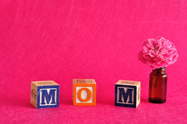 Mama słowo pisane z alfabet bloki na tle różowy, różowy kwiat — Zdjęcie stockowe