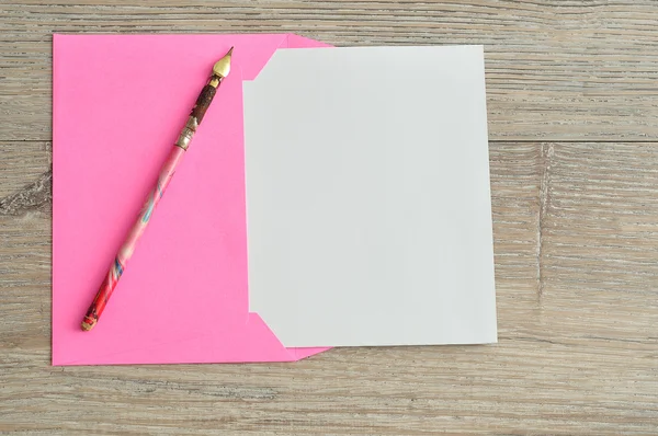 A pink envelope with a piece of paper sticking out — Stock Photo, Image