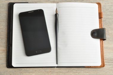 Akıllı telefon ve dolma kalemle görüntülenen açık bir dizüstü bilgisayar