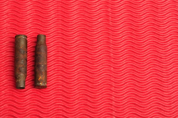 Две ржавые пули, изолированные на красном фоне — стоковое фото