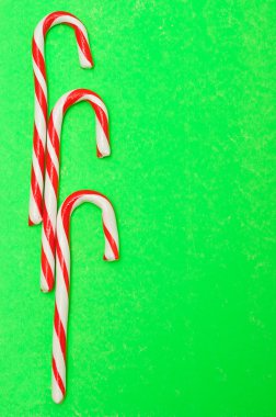 Yeşil bir arka plan üzerinde üç baston şekerler