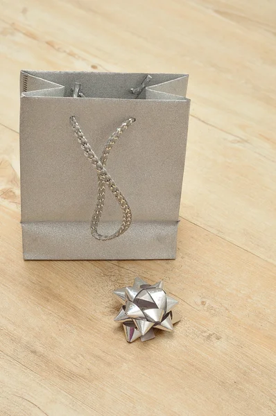 Una bolsa de regalo de plata con un arco —  Fotos de Stock