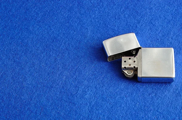 A silver lighter isolated on a blue background — Stock Photo, Image