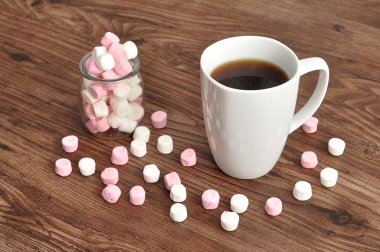 Bir kupa ve bir kavanoz küçük lokum ile dolu