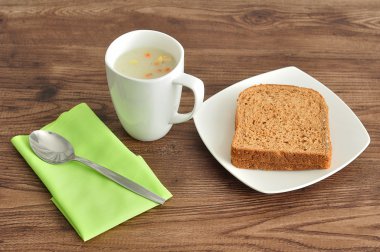 Sebze çorbası, ekmek, peçete ve çorba fincan