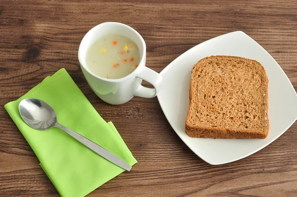 En mugg av grönsakssoppa, bröd, servett och soppa — Stockfoto
