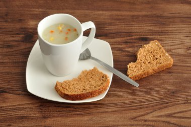 Sebze çorbası ekmek bir kırık parçaları ile görüntülenen bir kupa