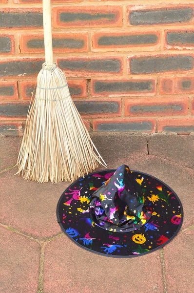 A colorful witches hat displayed with a broom — Stock Photo, Image