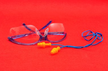 Koruyucu gözlük ve kırmızı bir arka plan üzerinde izole kulak tıkacı