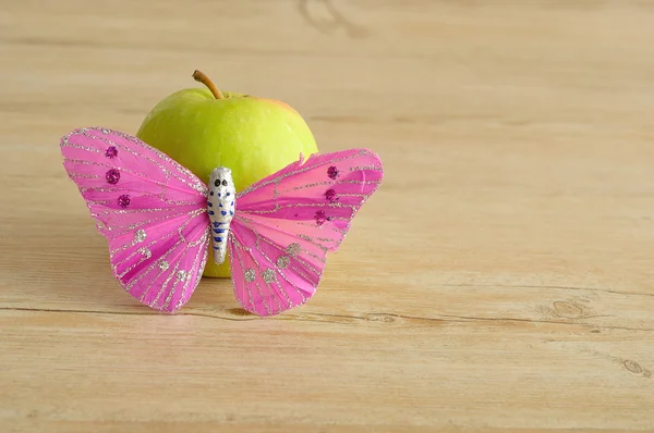 Una sola manzana verde mostrada con una mariposa rosa — Foto de Stock