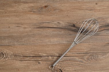 Yumurta çırpıcı, çırpma teli, bir ahşap arka plan üzerinde izole