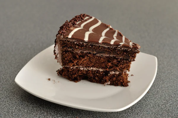 A delicious slice of chocolate cake in a white plate — Stock Photo, Image