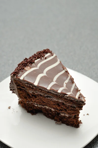 Una deliziosa fetta di torta al cioccolato in un piatto bianco — Foto Stock