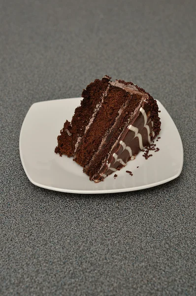 Una deliziosa fetta di torta al cioccolato in un piatto bianco — Foto Stock