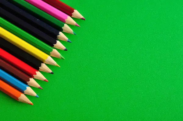 緑の背景に分離された色鉛筆 — ストック写真