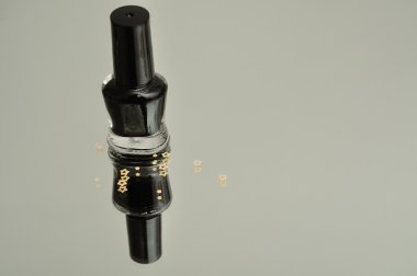 Siyah oje beyaz bir arka plan yansıtan bir şişe