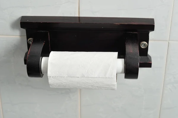 A wooden toilet paper roll holder with a roll of toilet paper — Stock Photo, Image