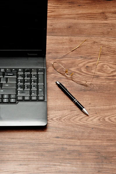 Laptop med glasögon och en penna — Stockfoto