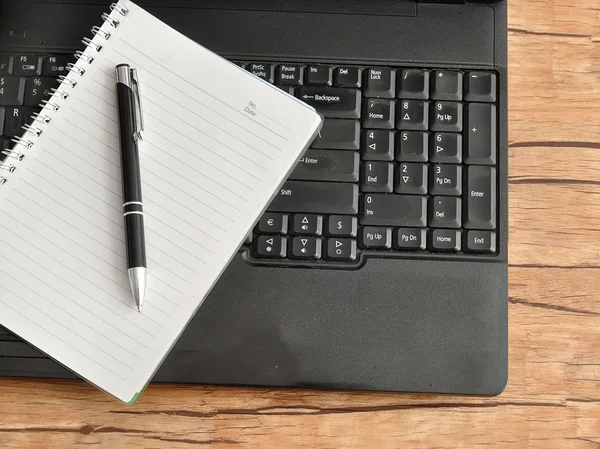 Laptop with a notebook and a pen — Stock Photo, Image