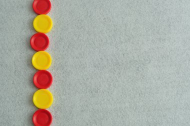 Beyaz bir arka planda sarı ve kırmızı plastik diskleri bir sınırla