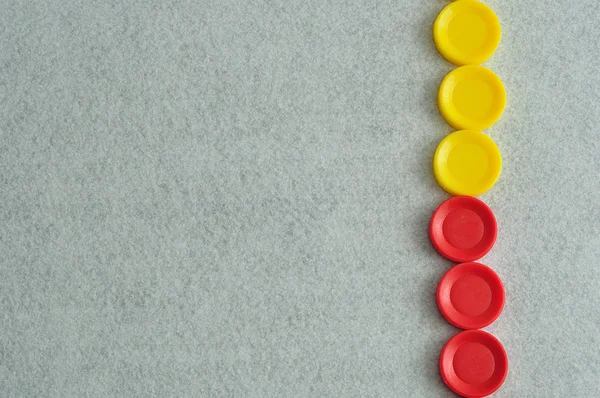 Uma borda com discos de plástico amarelo e vermelho em um fundo branco — Fotografia de Stock