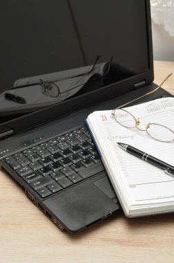 Gözlük, bir kalem ve bir açık günlük okuma ile bir dizüstü bilgisayar