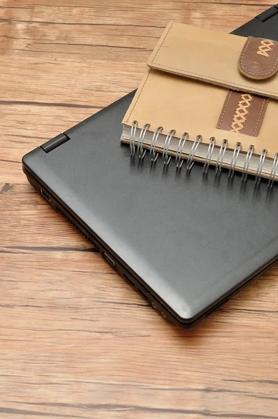 Laptop with a leather notebook — Stock Photo, Image