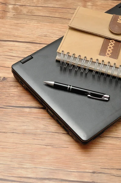 Laptop with a leather notebook and a pen — Stock Photo, Image