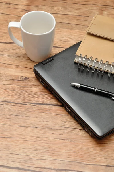 Laptop with a leather notebook, a pen and an empty white mug — Stock Photo, Image
