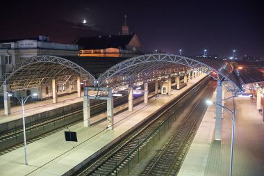 Brest, Belarus - 22 Ekim 2020 - Gece ay ışığında büyük bir tren istasyonu. Güzel tren istasyonu. Terk edilmiş platformlar