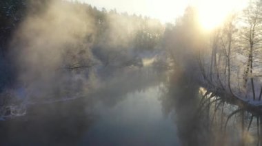Kış parkının hava manzarası. Nehirle kaplı güzel kış manzarası ve yukarıdan buzla kaplı beyaz ağaçlar. Kış doğal sahnesi