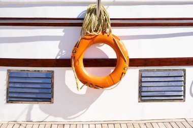 Yat güvertesinin arka planında can simidi var.